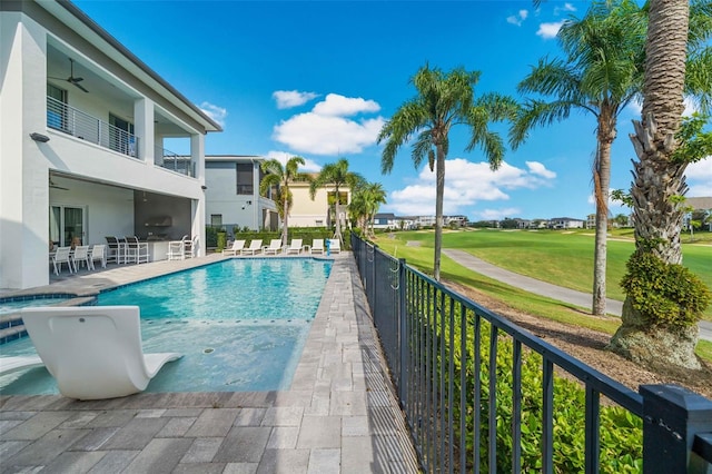 view of swimming pool with ceiling fan, a patio area, and exterior kitchen