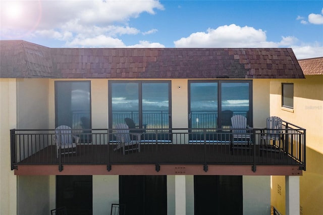 rear view of property featuring a balcony