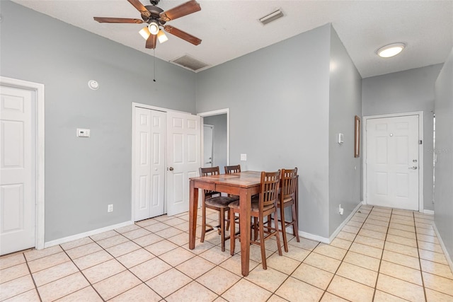 tiled dining room with ceiling fan and a textured ceiling