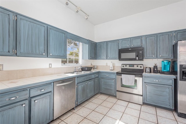 kitchen featuring stainless steel appliances, light tile patterned floors, and sink