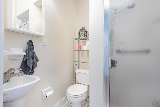 bathroom featuring walk in shower, tile patterned flooring, sink, and toilet