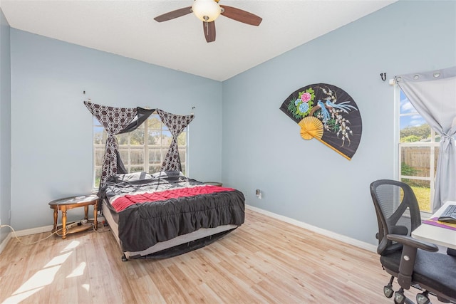 bedroom with light wood-type flooring, multiple windows, and ceiling fan