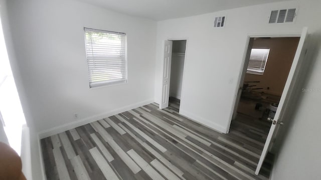 unfurnished bedroom with dark wood-type flooring and a closet