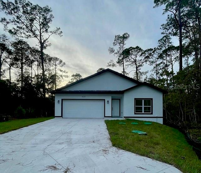 ranch-style home with a garage and a front yard