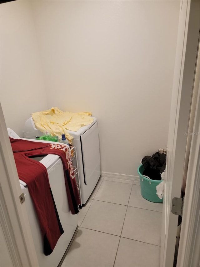 clothes washing area with light tile patterned floors and washer and dryer