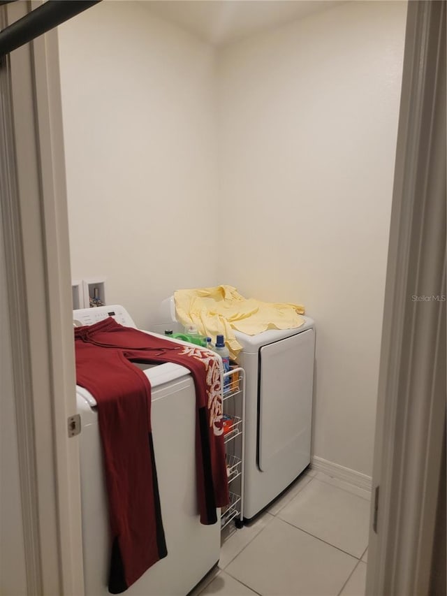 laundry room featuring washer and dryer and light tile patterned floors