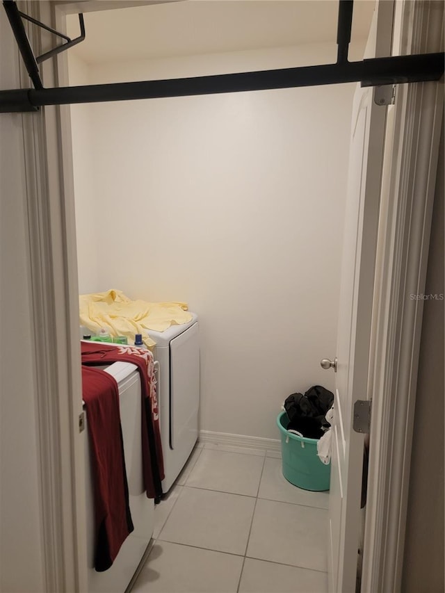 laundry room featuring washer and clothes dryer and light tile patterned floors