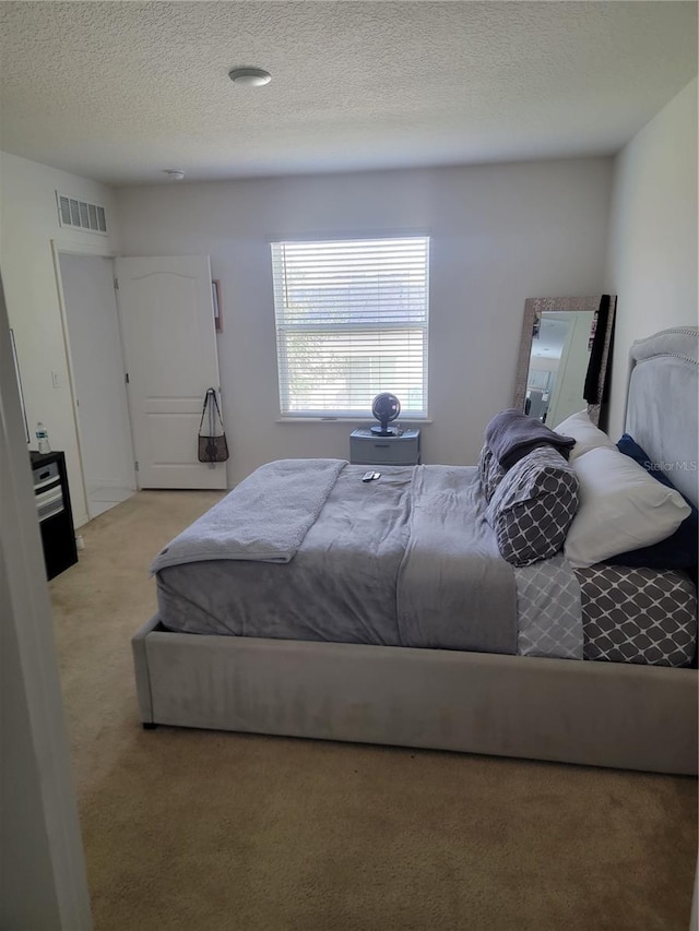 carpeted bedroom featuring a textured ceiling