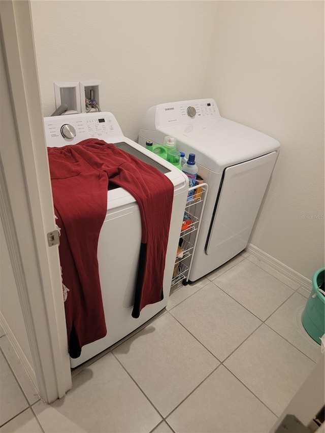 laundry area featuring washing machine and clothes dryer and light tile patterned floors