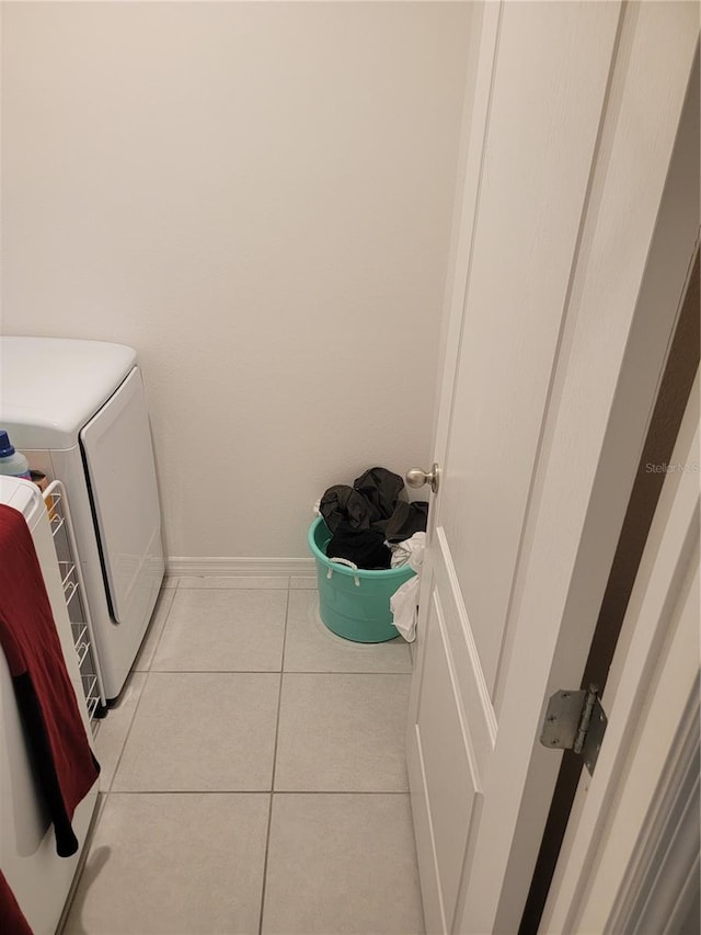 washroom with separate washer and dryer and light tile patterned floors