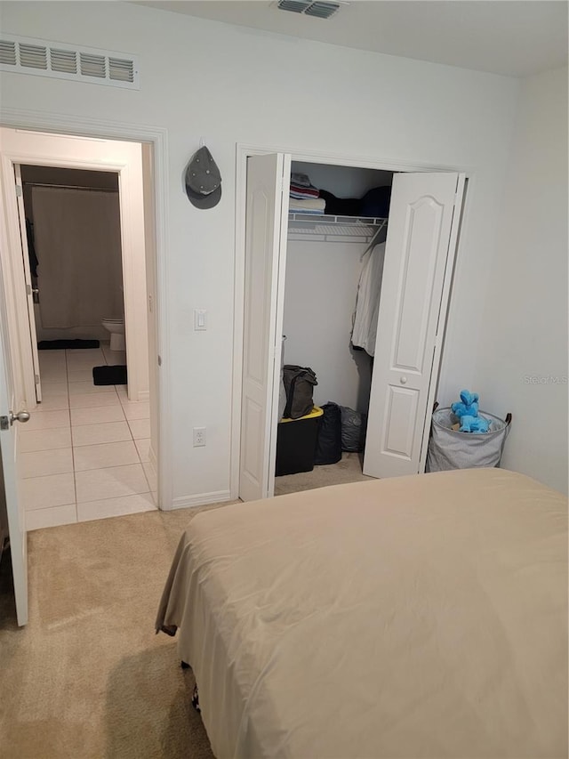 bedroom featuring light colored carpet and a closet