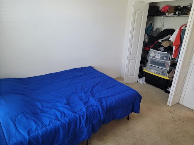 bedroom with light colored carpet and a closet