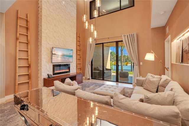 living room with a high ceiling and a stone fireplace