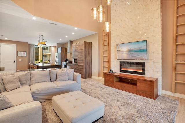 living room with built in shelves, a fireplace, and light hardwood / wood-style floors