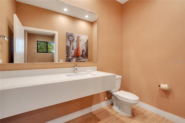 bathroom featuring toilet, sink, and hardwood / wood-style floors