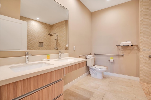 bathroom with toilet, vanity, and tiled shower