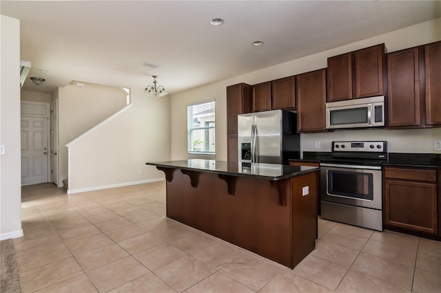 kitchen featuring a kitchen breakfast bar, pendant lighting, a kitchen island, appliances with stainless steel finishes, and a chandelier