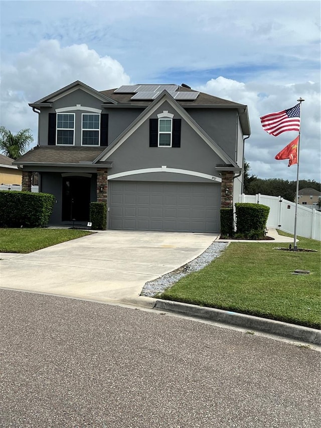 view of front of property featuring a front lawn, a garage, and solar panels