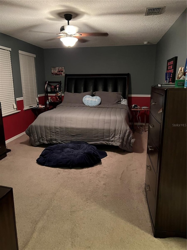 bedroom featuring carpet flooring, a textured ceiling, and ceiling fan