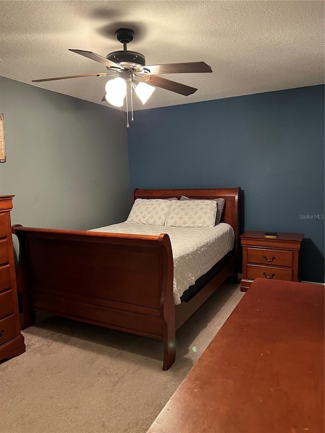 bedroom featuring a textured ceiling, light carpet, and ceiling fan