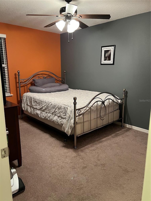 carpeted bedroom with a textured ceiling and ceiling fan