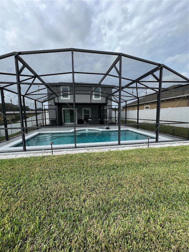 view of pool featuring a lanai and a lawn