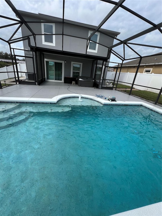 view of pool featuring glass enclosure and a patio area