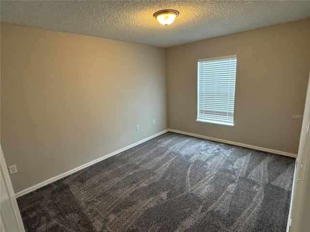 unfurnished room with a textured ceiling and dark carpet