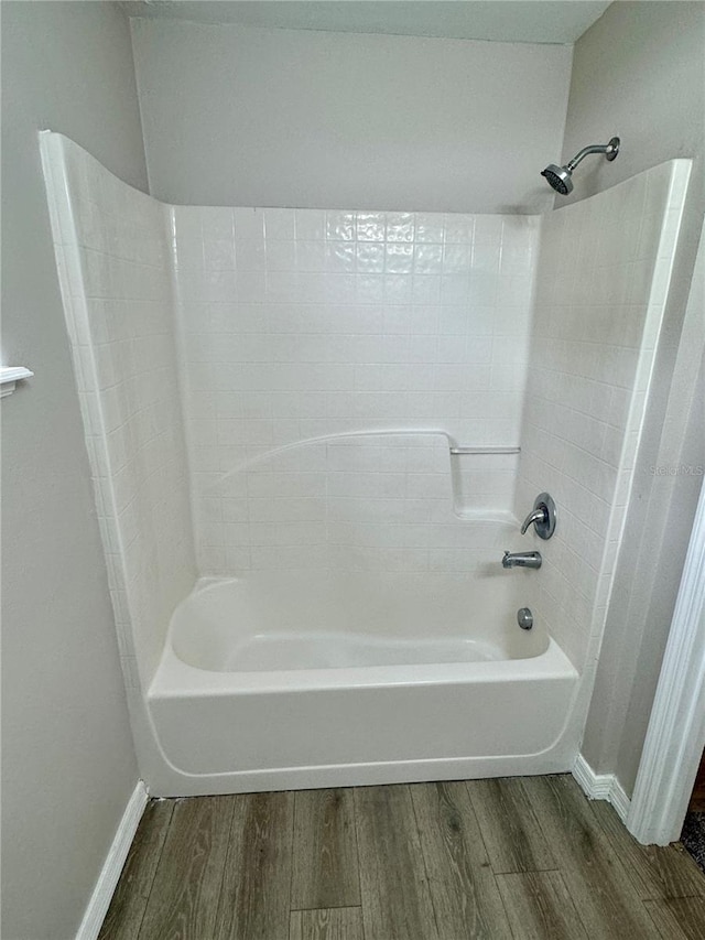 bathroom featuring wood-type flooring and bathtub / shower combination