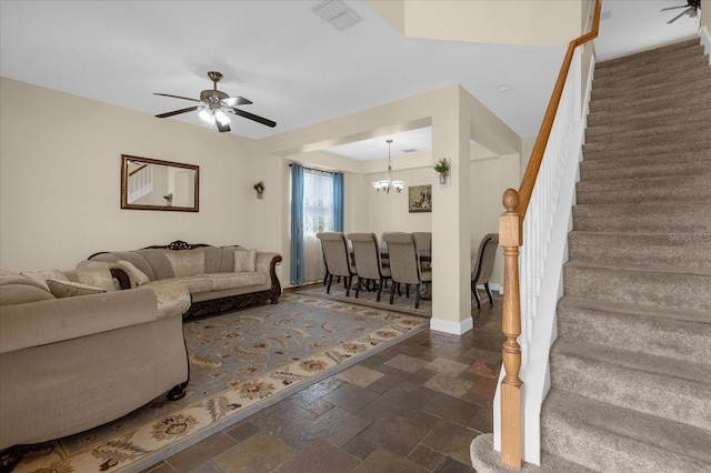 living room featuring ceiling fan with notable chandelier