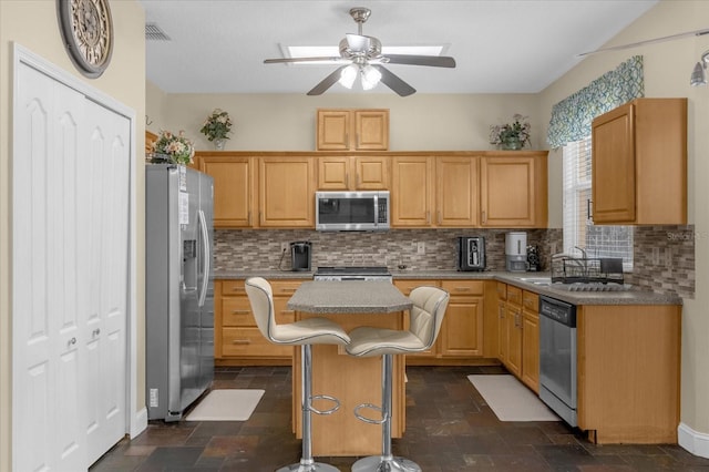 kitchen with a kitchen island, sink, stainless steel appliances, and tasteful backsplash