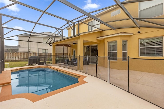 view of swimming pool with glass enclosure, ceiling fan, and a patio area