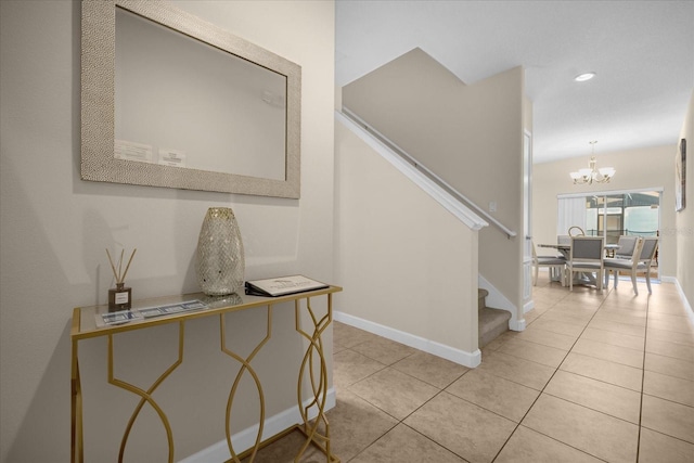 stairs featuring tile patterned flooring and an inviting chandelier