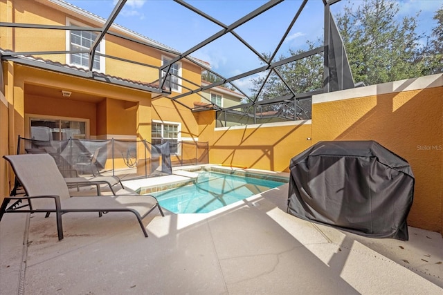 view of swimming pool featuring glass enclosure, a grill, and a patio area