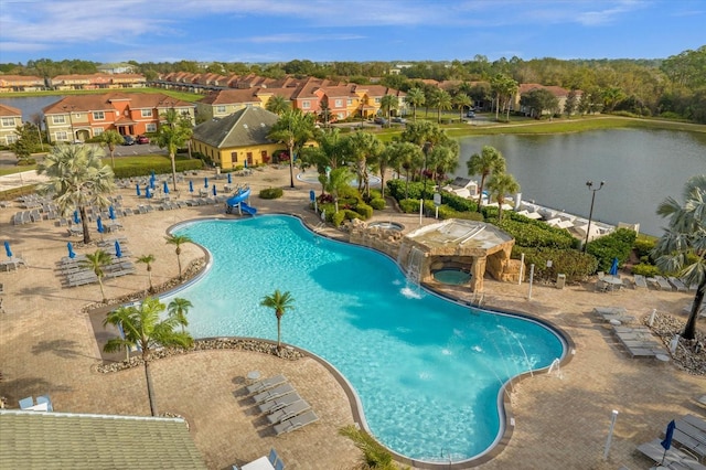 view of swimming pool with a patio area, pool water feature, and a water view