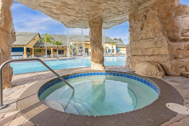 view of swimming pool featuring a hot tub