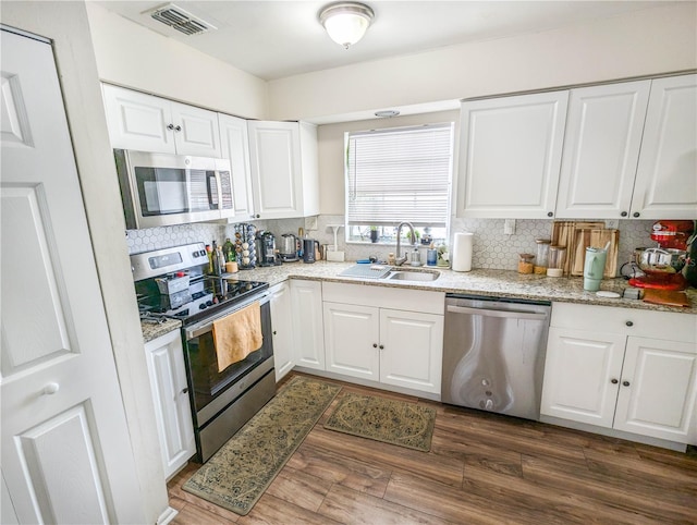 kitchen featuring white cabinets, sink, appliances with stainless steel finishes, tasteful backsplash, and dark hardwood / wood-style flooring