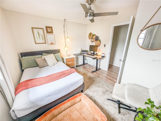 bedroom featuring a textured ceiling, light hardwood / wood-style floors, and ceiling fan