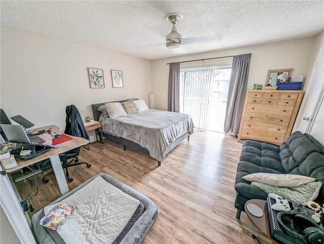 bedroom featuring ceiling fan, a textured ceiling, access to outside, and light hardwood / wood-style flooring