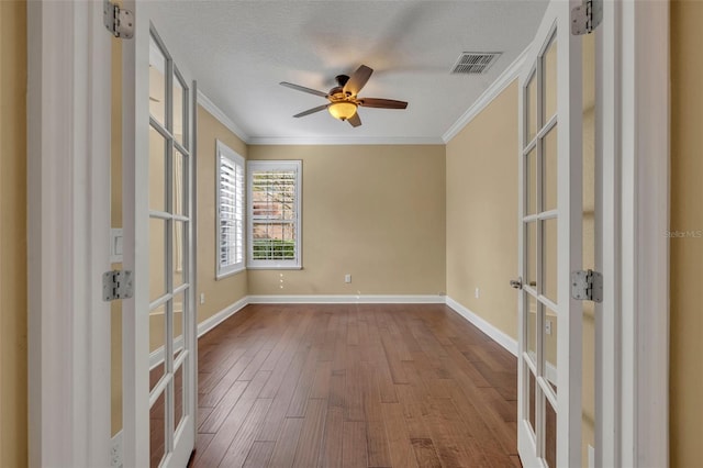 unfurnished room with a textured ceiling, french doors, ceiling fan, and wood-type flooring