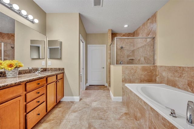 bathroom featuring vanity, independent shower and bath, tile patterned flooring, and a textured ceiling