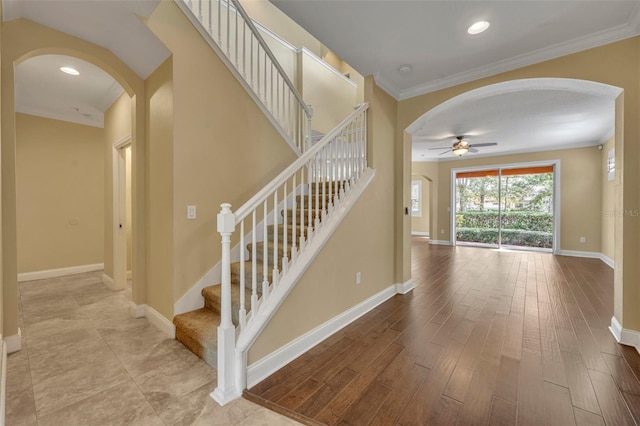 stairs featuring hardwood / wood-style flooring, ceiling fan, and crown molding