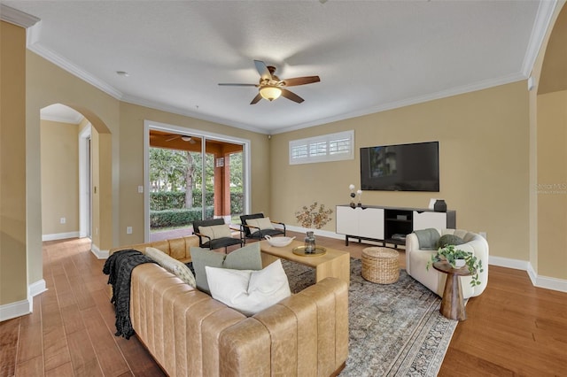 living room with ornamental molding, hardwood / wood-style flooring, and ceiling fan