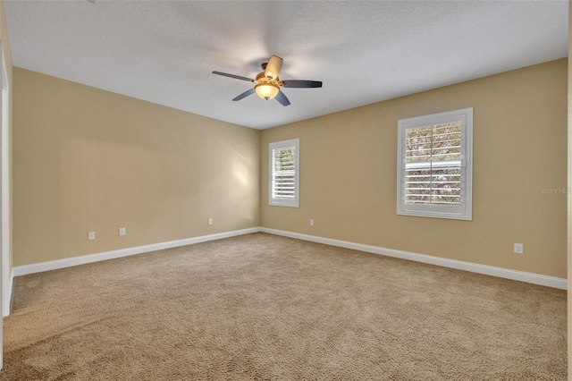 carpeted empty room featuring ceiling fan, a healthy amount of sunlight, and a textured ceiling