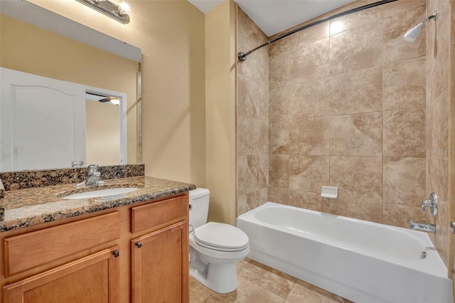 full bathroom featuring toilet, tiled shower / bath combo, vanity, and tile patterned flooring