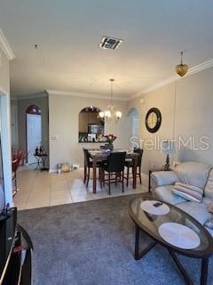 tiled living room with crown molding and a chandelier