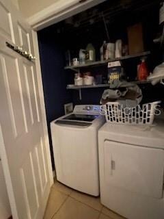 laundry area featuring washing machine and dryer and light tile patterned floors