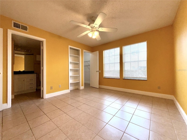 unfurnished bedroom featuring a textured ceiling, ceiling fan, and light tile patterned floors