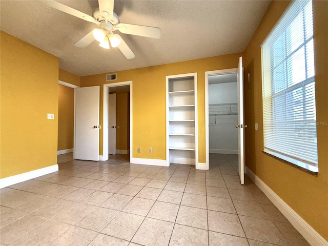 unfurnished bedroom with ceiling fan, a textured ceiling, and light tile patterned floors