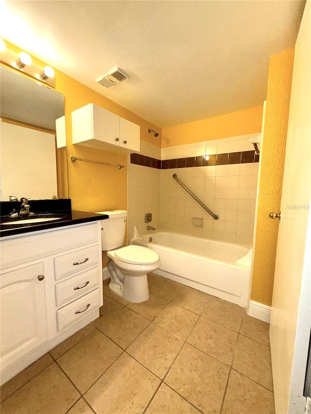 full bathroom featuring toilet, tiled shower / bath combo, vanity, and tile patterned floors